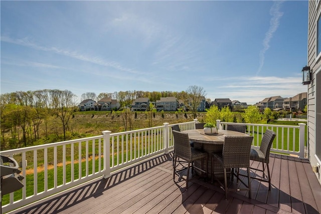 wooden terrace with a yard, a residential view, and outdoor dining space