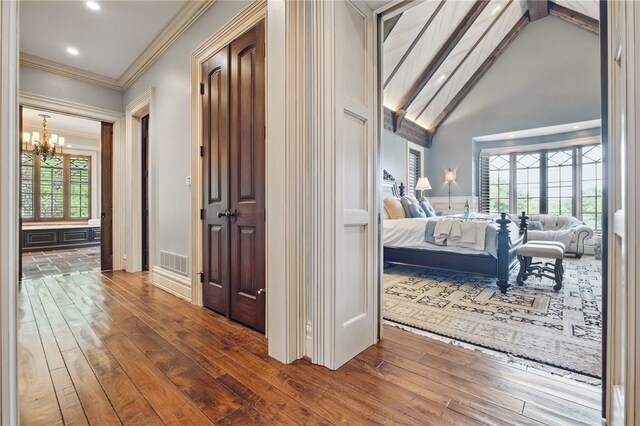 corridor featuring visible vents, crown molding, wood-type flooring, an inviting chandelier, and recessed lighting