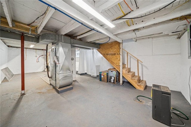 basement with heating unit and stairway