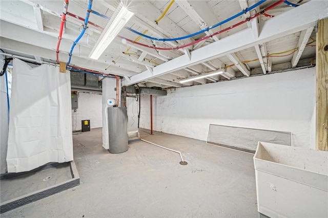 unfinished basement featuring electric panel and gas water heater