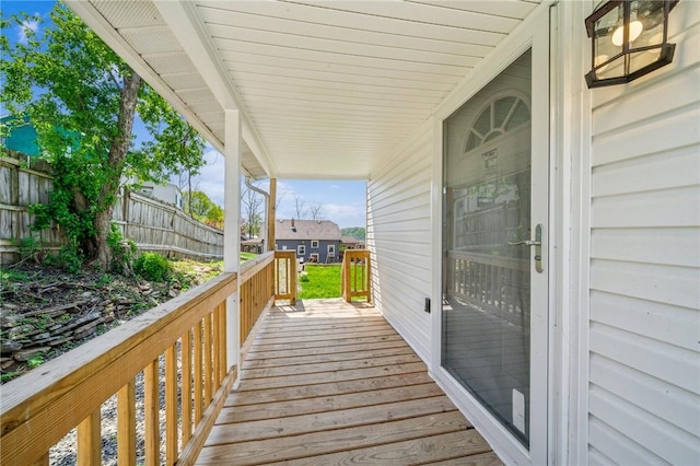 deck featuring covered porch and fence