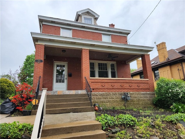 view of front of house with brick siding, a ceiling fan, and a porch