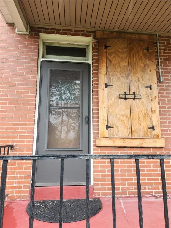 doorway to property with brick siding