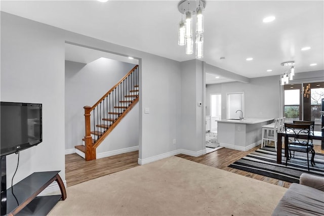 living room featuring stairway, baseboards, and wood finished floors
