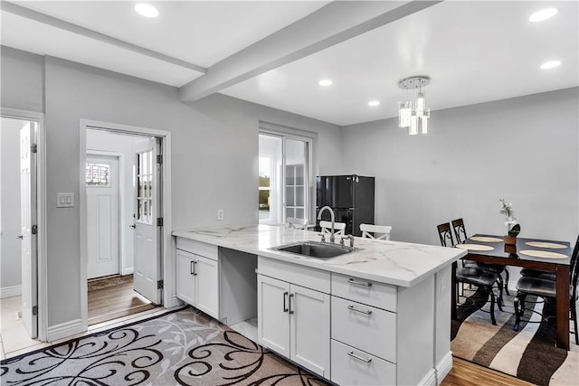 kitchen featuring recessed lighting, white cabinetry, a sink, and a peninsula