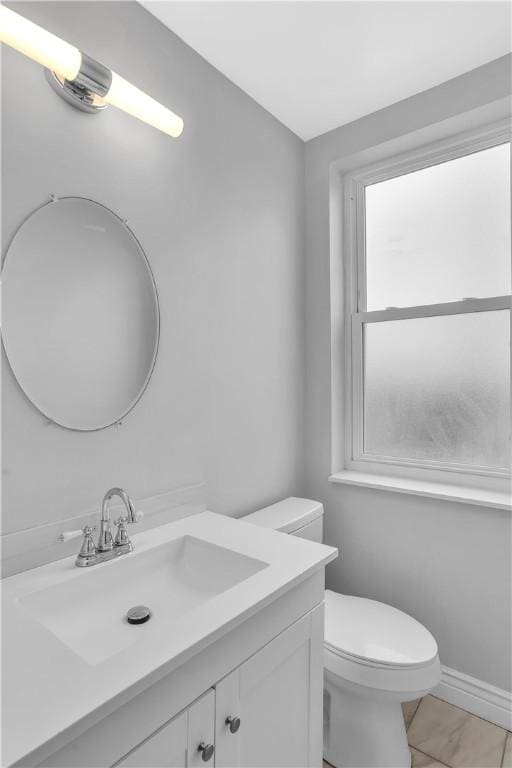 half bath featuring vanity and toilet