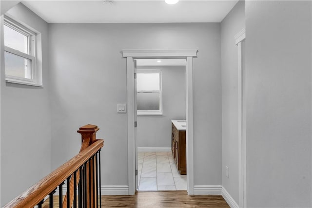 corridor with baseboards, recessed lighting, and an upstairs landing