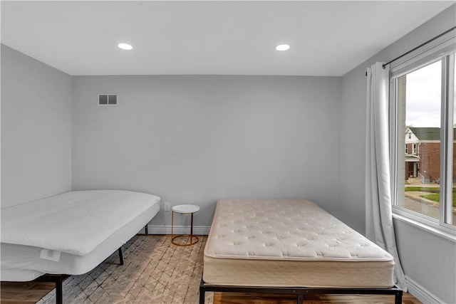 bedroom with baseboards, visible vents, and multiple windows