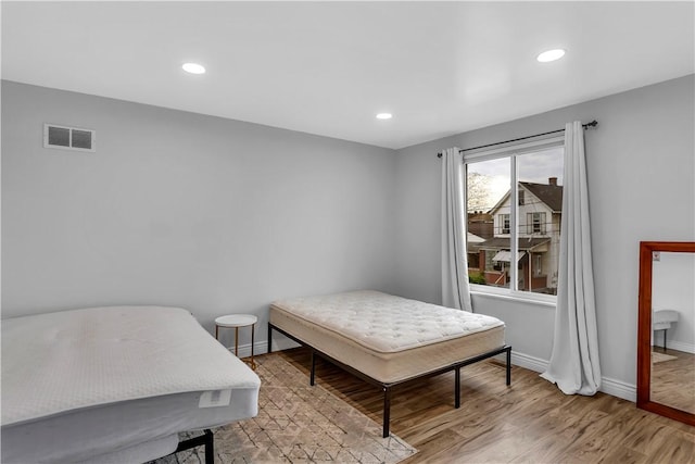 bedroom featuring visible vents, recessed lighting, baseboards, and wood finished floors