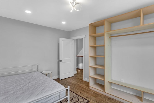 bedroom with recessed lighting, baseboards, and wood finished floors