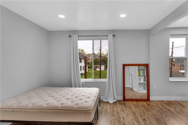 bedroom with baseboards, recessed lighting, and light wood-style floors