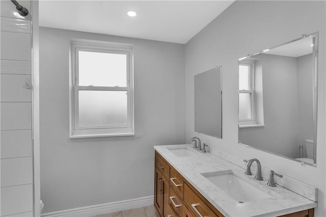 full bath with a sink, toilet, and a healthy amount of sunlight