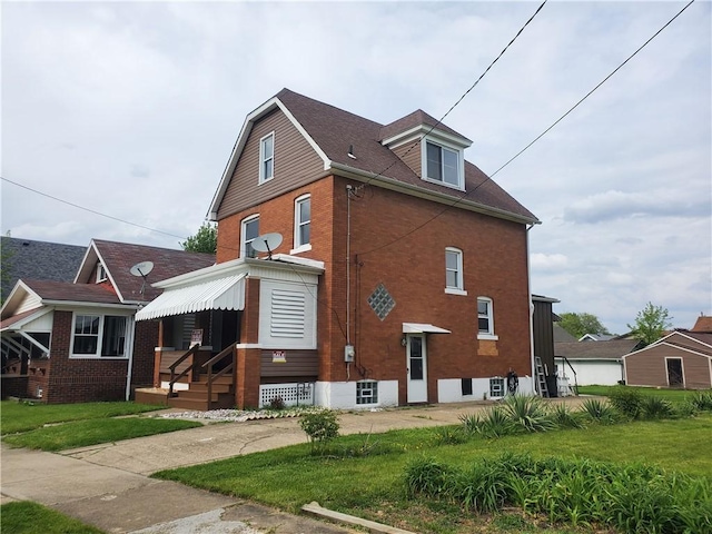 view of home's exterior featuring brick siding and a yard