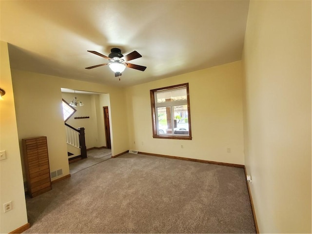 empty room featuring a healthy amount of sunlight, stairway, and carpet flooring