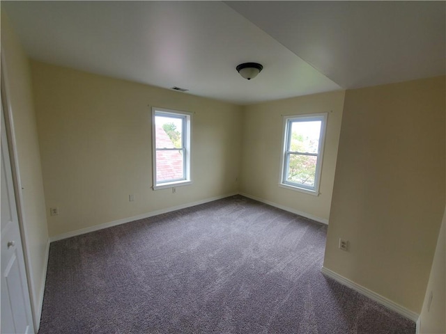 carpeted spare room with baseboards and visible vents