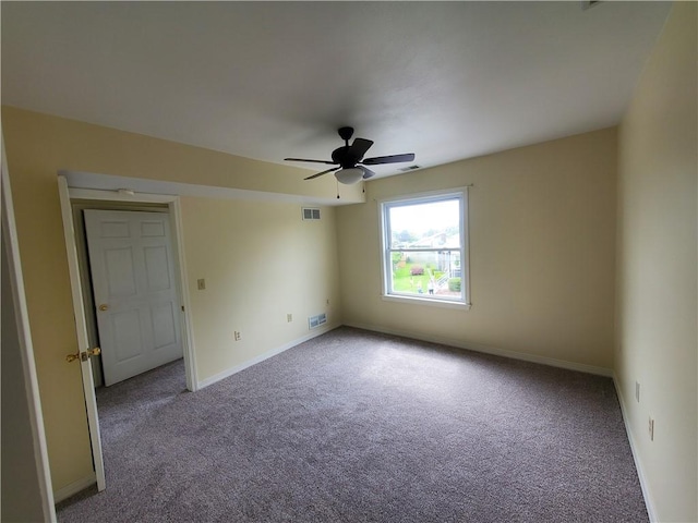 carpeted spare room with a ceiling fan, baseboards, and visible vents