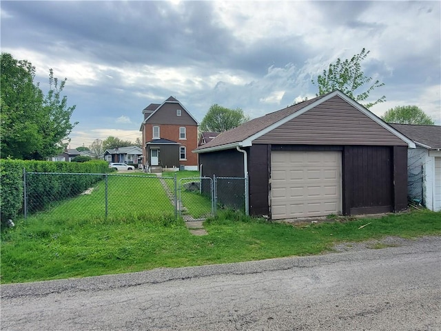 detached garage featuring fence and a gate