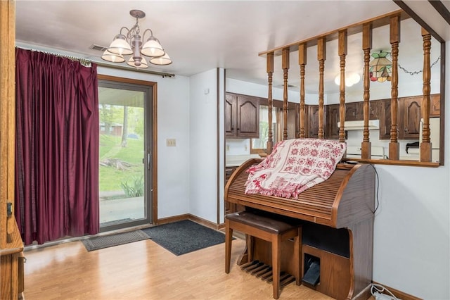 interior space with an inviting chandelier, light wood finished floors, and baseboards