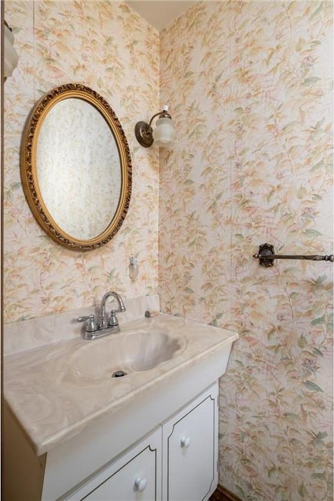 bathroom with vanity and wallpapered walls