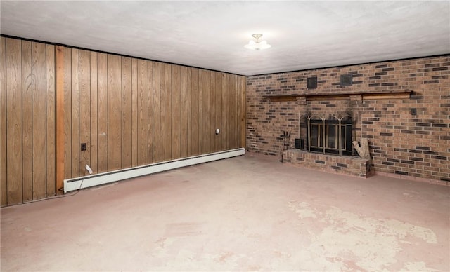 unfurnished living room featuring wood walls, a baseboard heating unit, and a fireplace