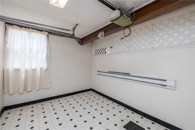 basement with baseboards, light floors, and a baseboard heating unit