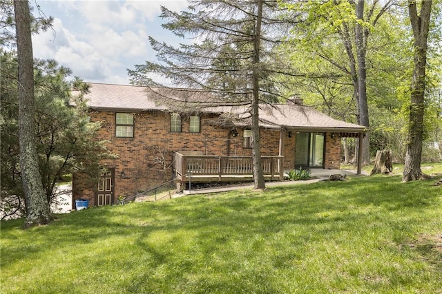view of front of property with brick siding, a wooden deck, and a front yard