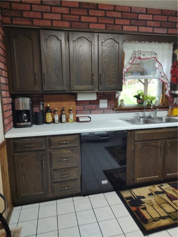 kitchen featuring a sink, light countertops, light tile patterned floors, and dark brown cabinets