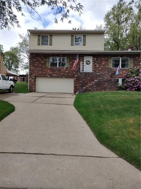 100 Forest Dr, Natrona Hts/Harrison Twp, PA 15065 - view of front of house featuring a garage, concrete driveway, a front lawn, and brick siding