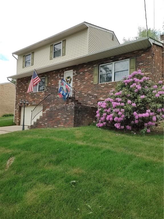 100 Forest Dr, Natrona Hts/Harrison Twp, PA 15065 - view of front of property with brick siding, a front yard, and a garage