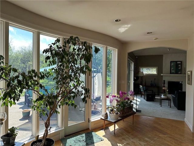 doorway to outside featuring arched walkways and wood finished floors
