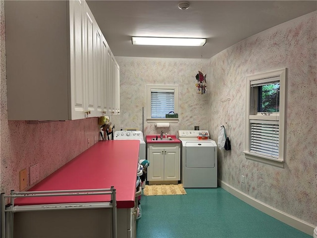 clothes washing area with cabinet space, baseboards, a healthy amount of sunlight, and a sink