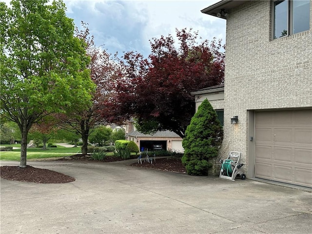 view of property exterior with concrete driveway and a garage