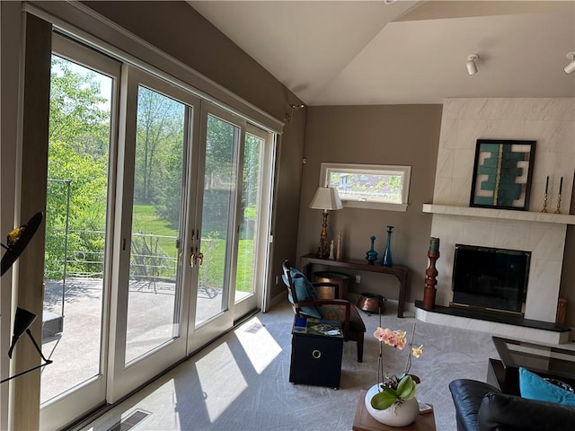 carpeted living room featuring vaulted ceiling, visible vents, and a fireplace