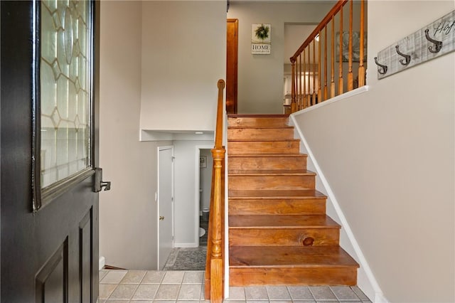 stairway featuring tile patterned flooring and baseboards