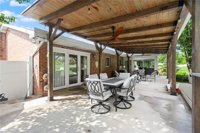 view of patio featuring a ceiling fan, fence, and outdoor dining space