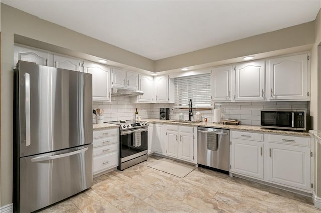 kitchen with decorative backsplash, stainless steel appliances, white cabinetry, and under cabinet range hood