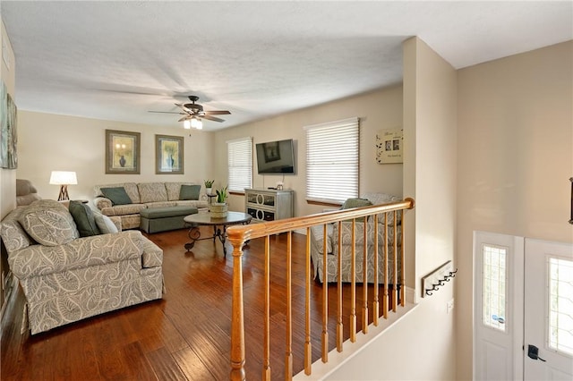 living room with ceiling fan and dark wood-type flooring