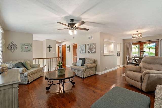 living area with baseboards, visible vents, wood finished floors, and ceiling fan with notable chandelier