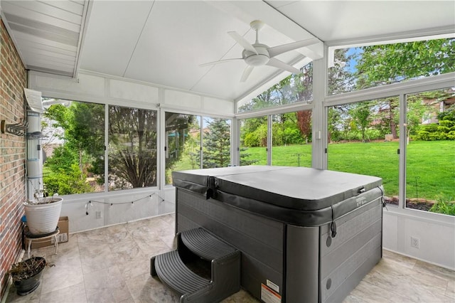 sunroom featuring a hot tub, a ceiling fan, and beam ceiling