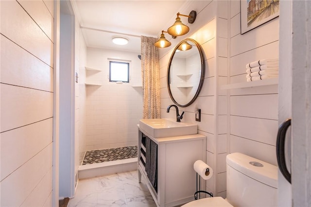 bathroom with vanity, toilet, tiled shower, and marble finish floor