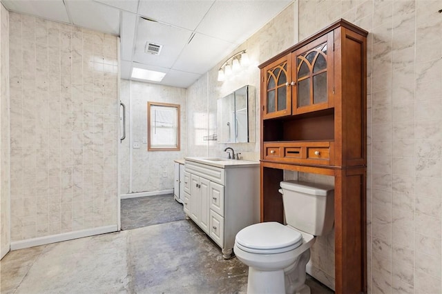 bathroom with vanity, toilet, concrete floors, visible vents, and a stall shower