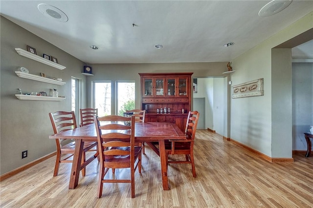 dining area featuring baseboards and light wood finished floors