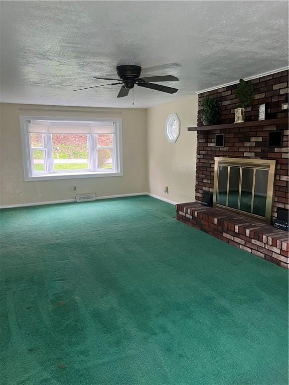 unfurnished living room with carpet flooring, ceiling fan, a fireplace, a textured ceiling, and baseboards