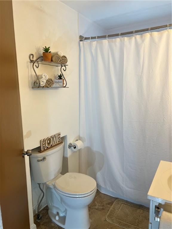 bathroom featuring toilet, a shower with curtain, and vanity