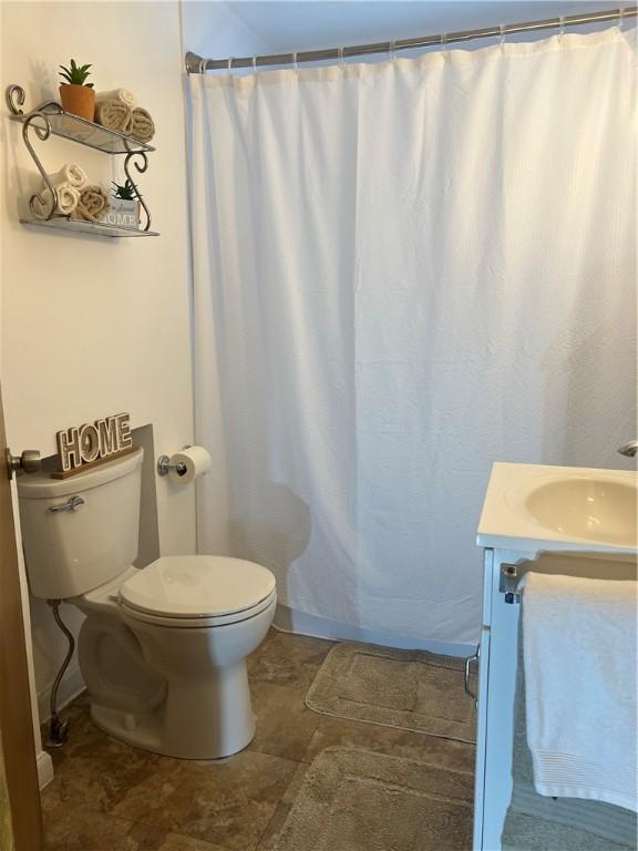 bathroom featuring vanity, toilet, and a shower with curtain