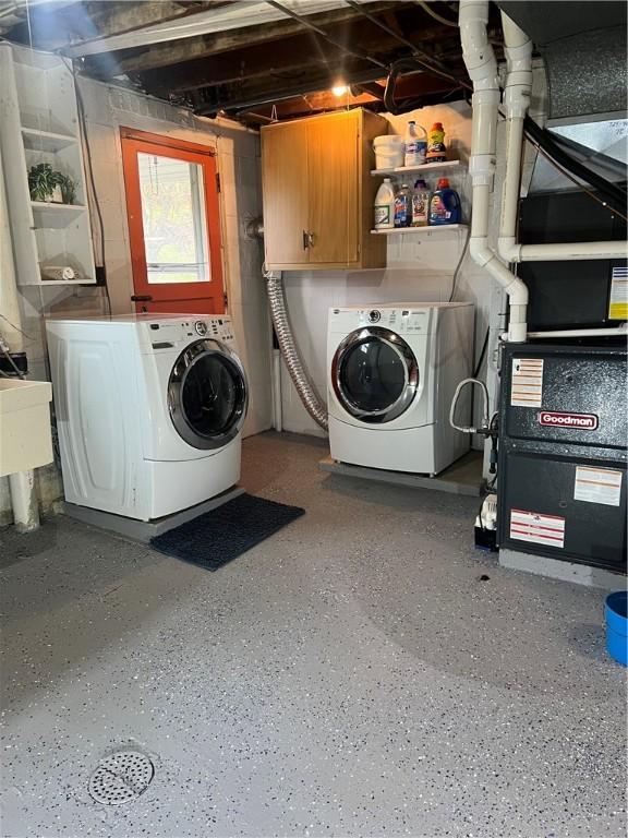 washroom with a sink, heating unit, and washer and clothes dryer