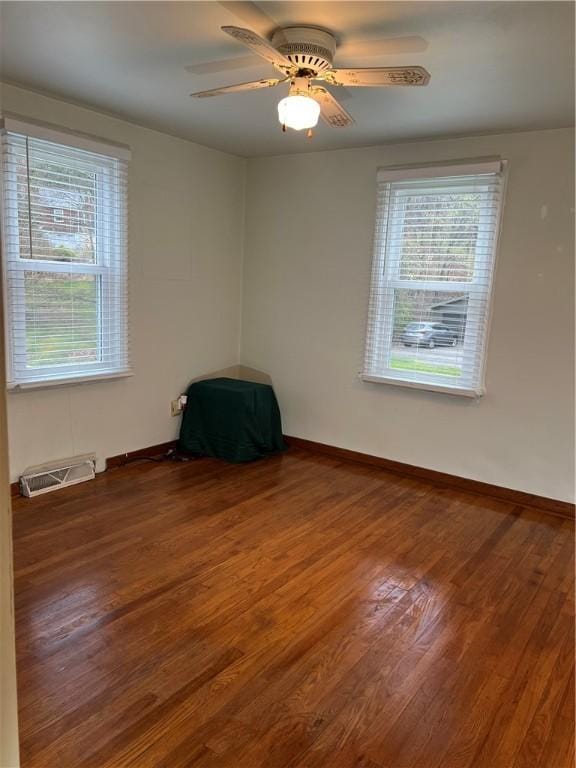 unfurnished room with visible vents, wood finished floors, and a wealth of natural light