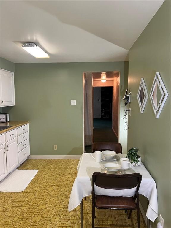 dining area with baseboards and lofted ceiling