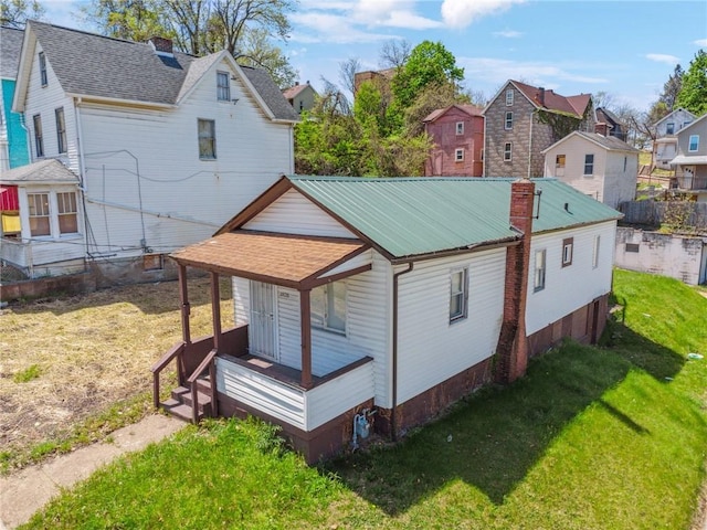 view of property exterior featuring a yard, a residential view, and covered porch