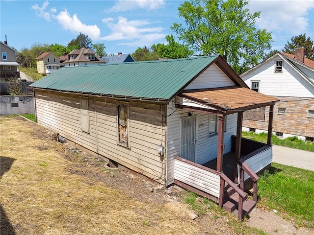 view of home's exterior with a porch and metal roof